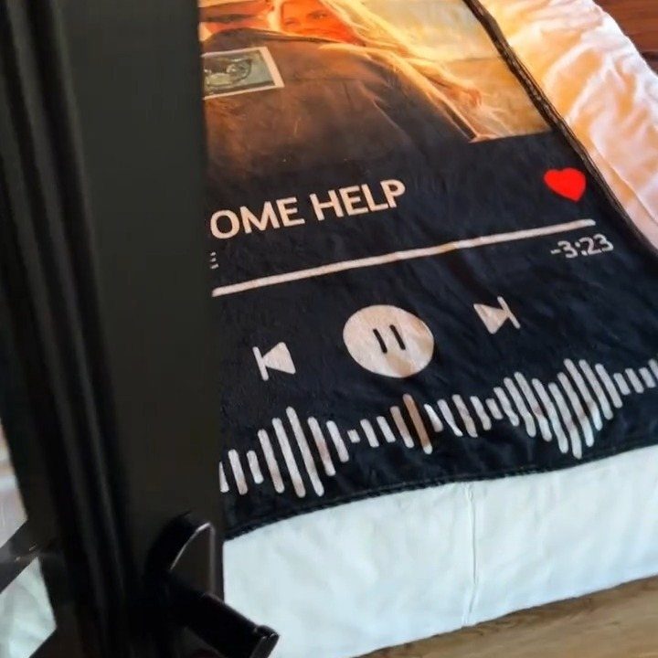 Custom throw blanket with music player design and photo on a white bed