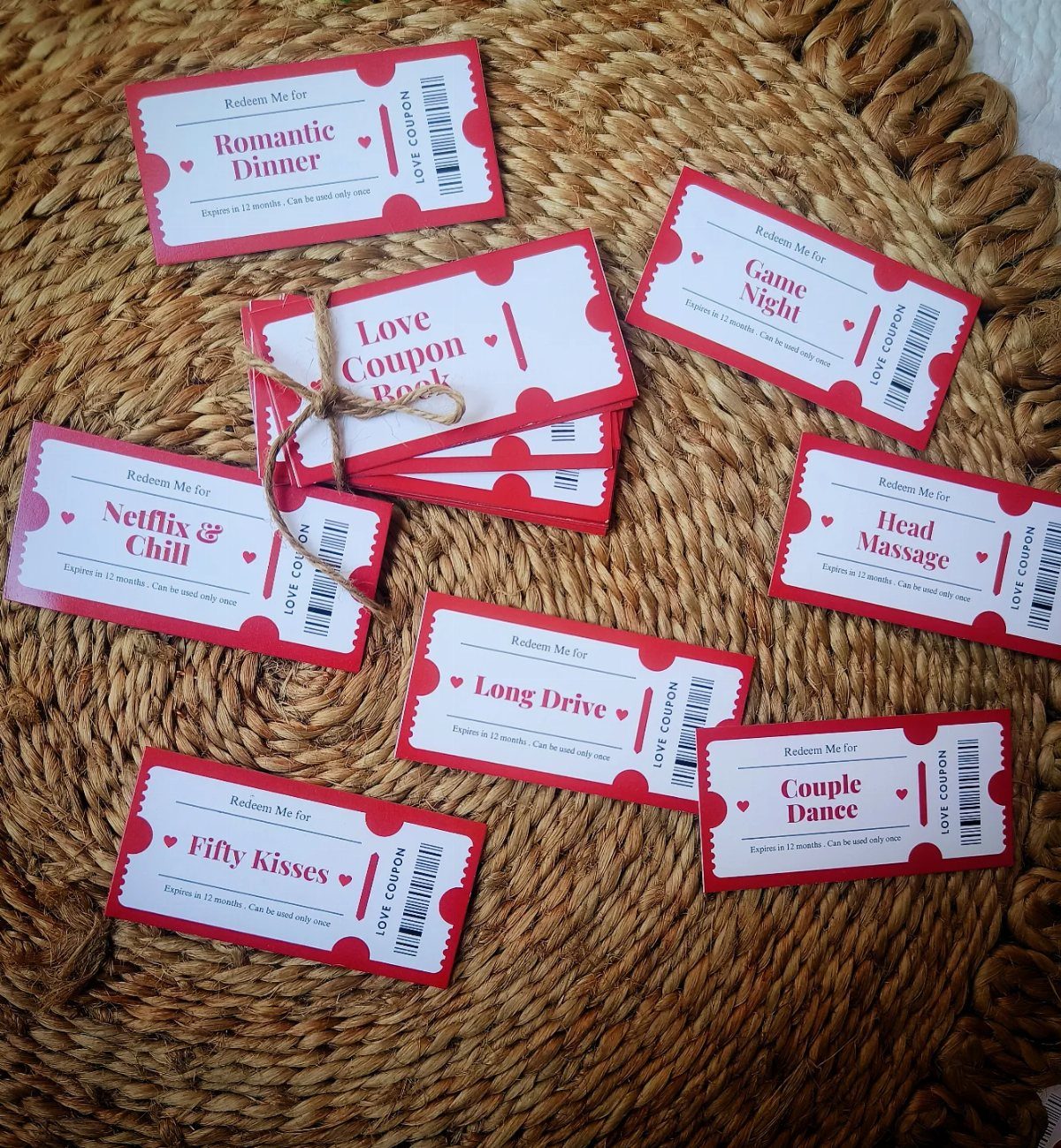 Love coupon tickets with romantic activities tied with twine on a straw mat.