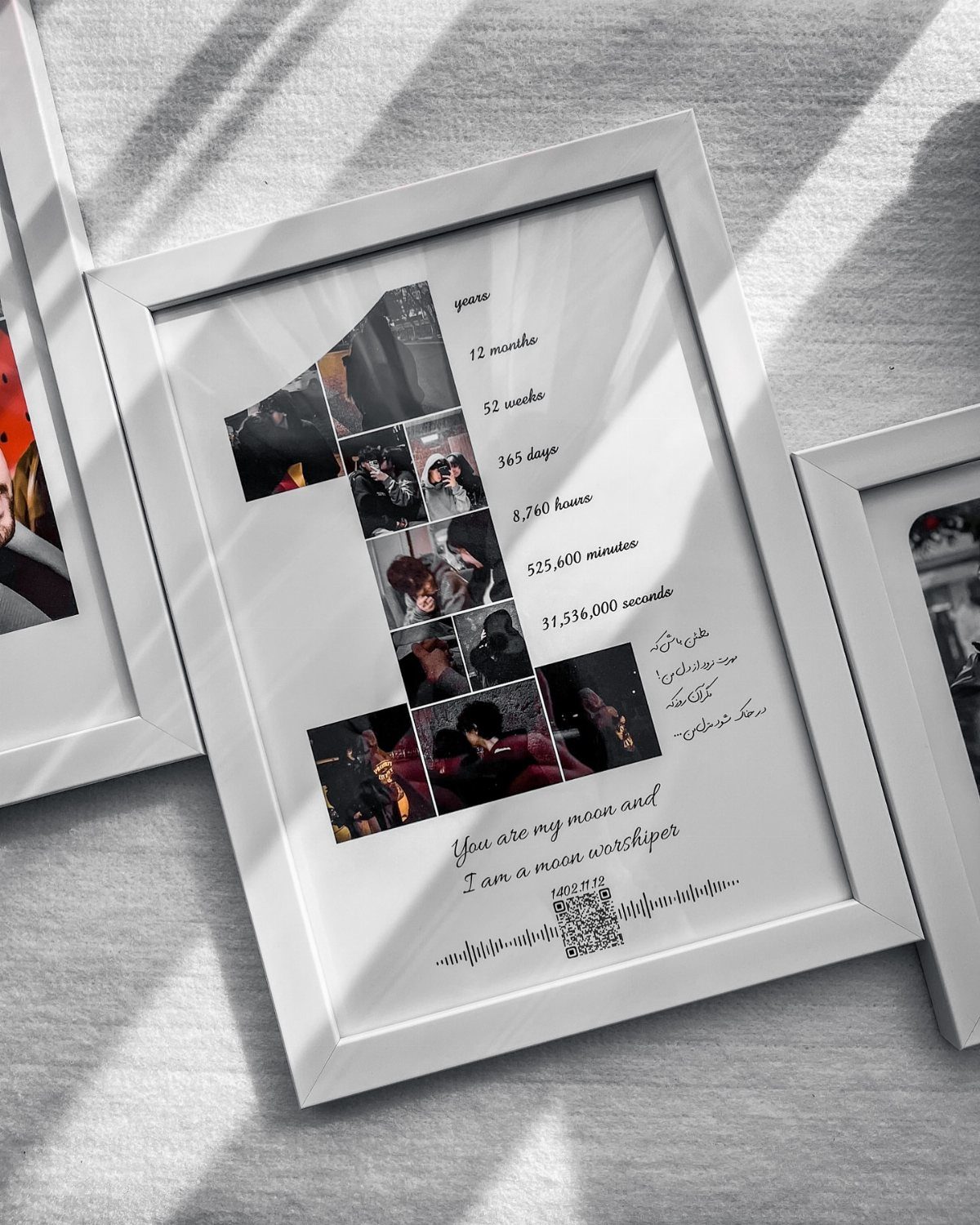 White framed anniversary poster with photos forming a number one and romantic text.