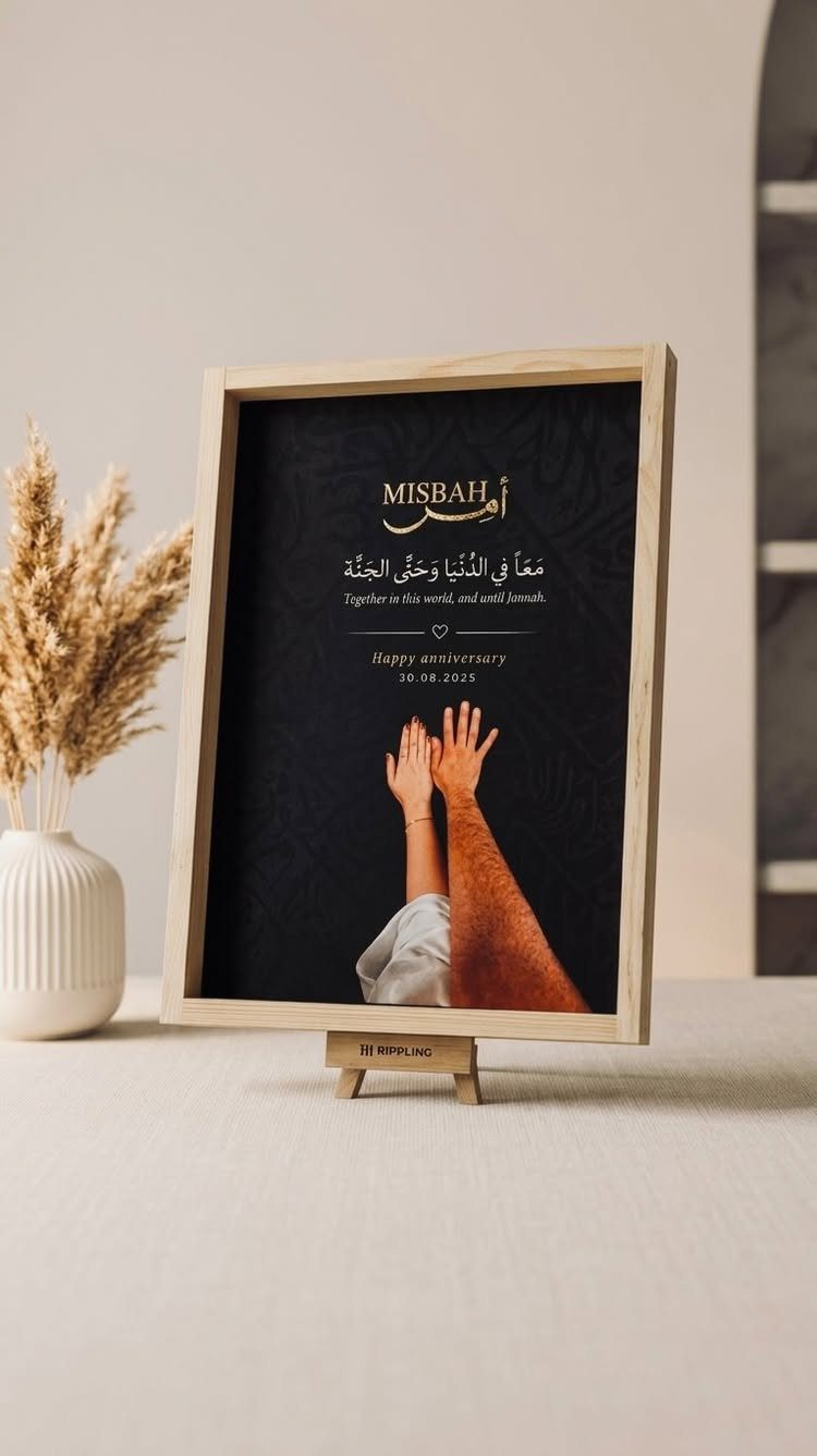 Framed anniversary print with gold calligraphy and a photo of touching hands.
