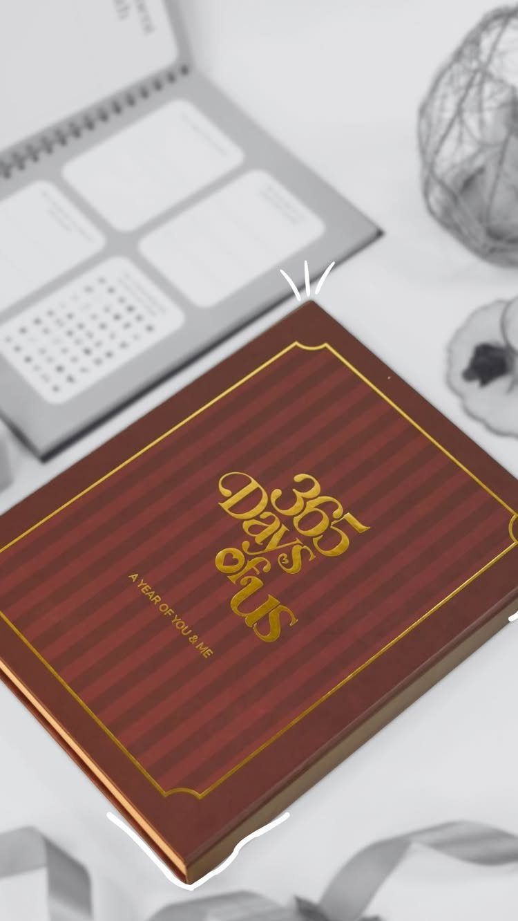 Red hardcover journal with gold lettering titled 365 Days of Us on white surface