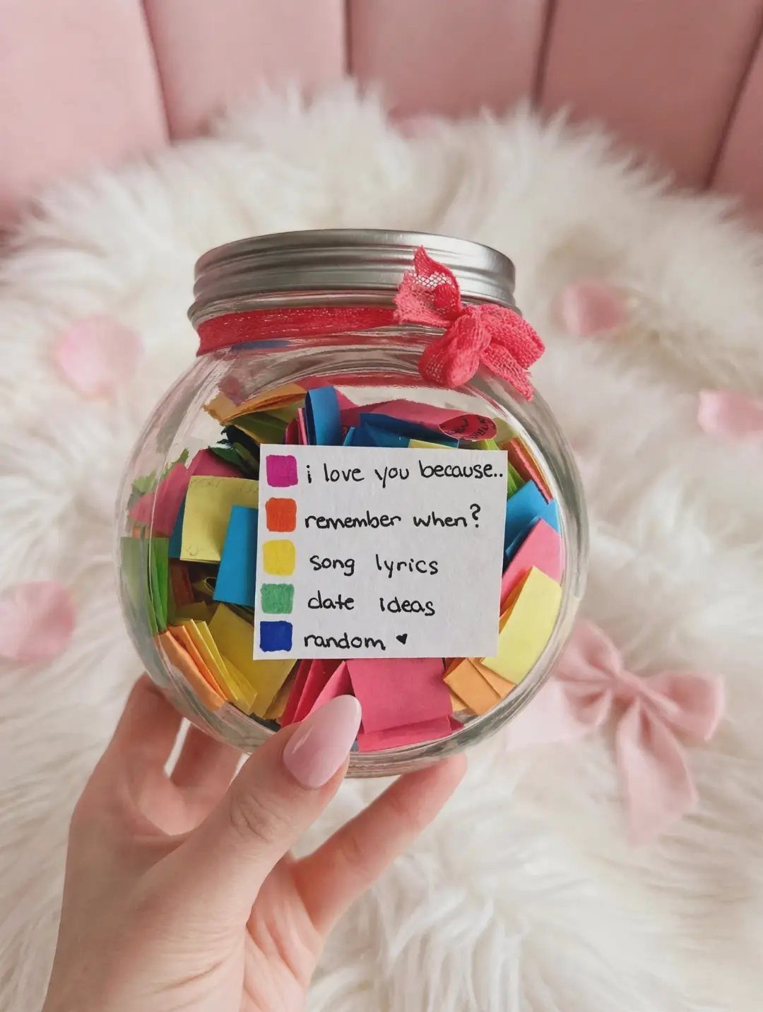 Glass jar filled with colorful paper slips and a category label held by hand.