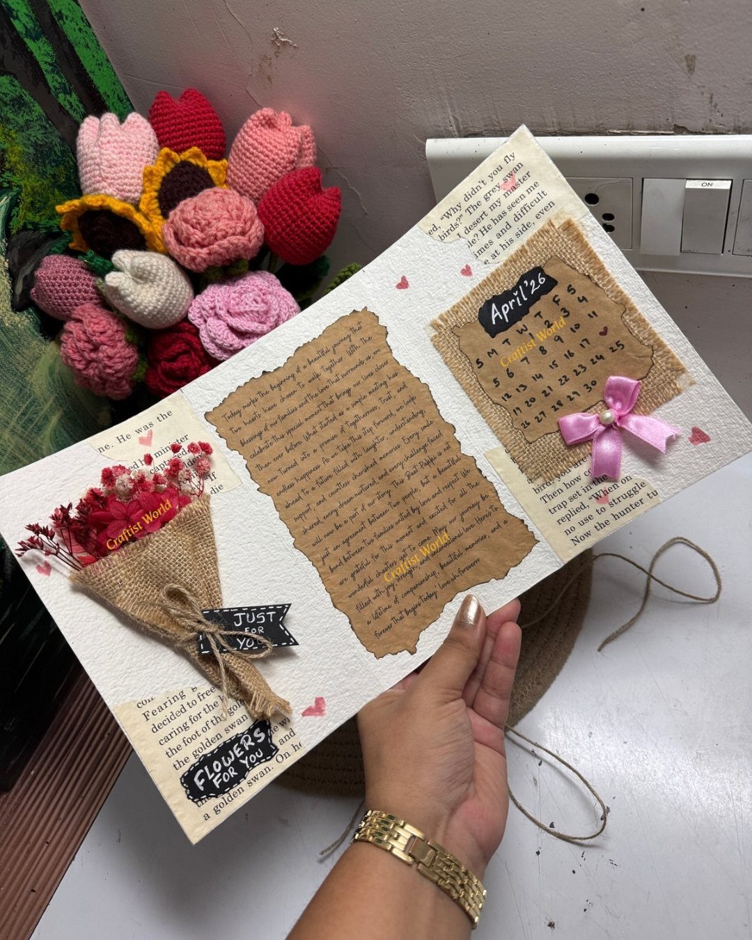 Handmade scrapbook page with a parchment letter, April calendar, and dried red flowers.
