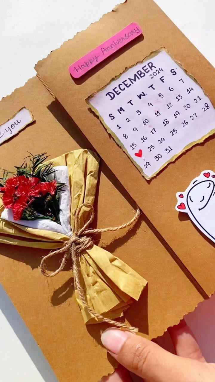 Handmade anniversary card with a December calendar and a small paper flower bouquet.