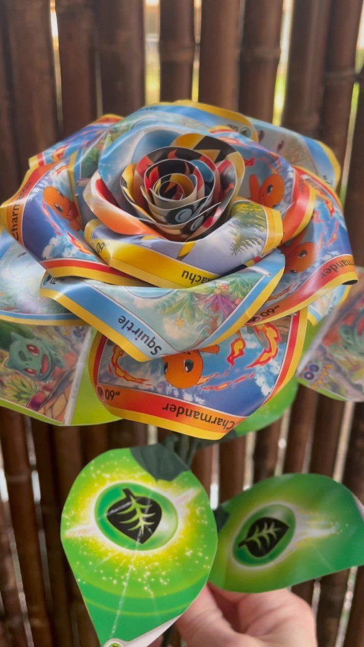 Rose made from rolled Pokemon trading cards with green card leaves and bamboo background