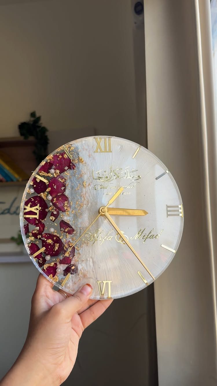 Round resin clock with gold accents and embedded red dried flower petals.
