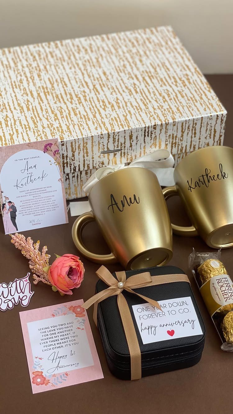 Gold personalized mugs and a black gift box with an anniversary card.