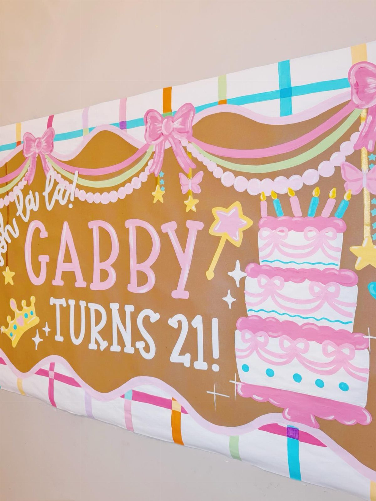 Painted 21st birthday banner featuring pink bows, pearl accents, and a tiered cake.