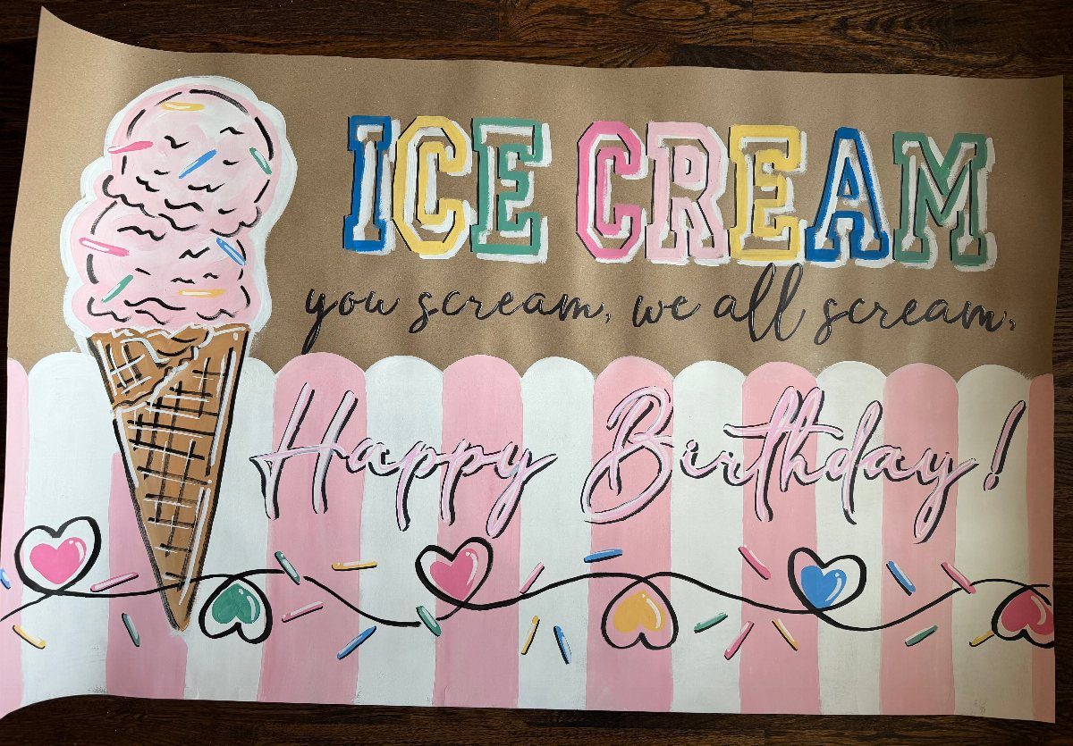 Hand-painted birthday banner with a pink ice cream cone and colorful lettering.