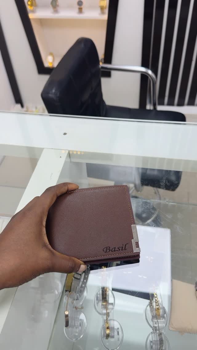 Brown leather bifold wallet with the name Basil embossed on the front cover.