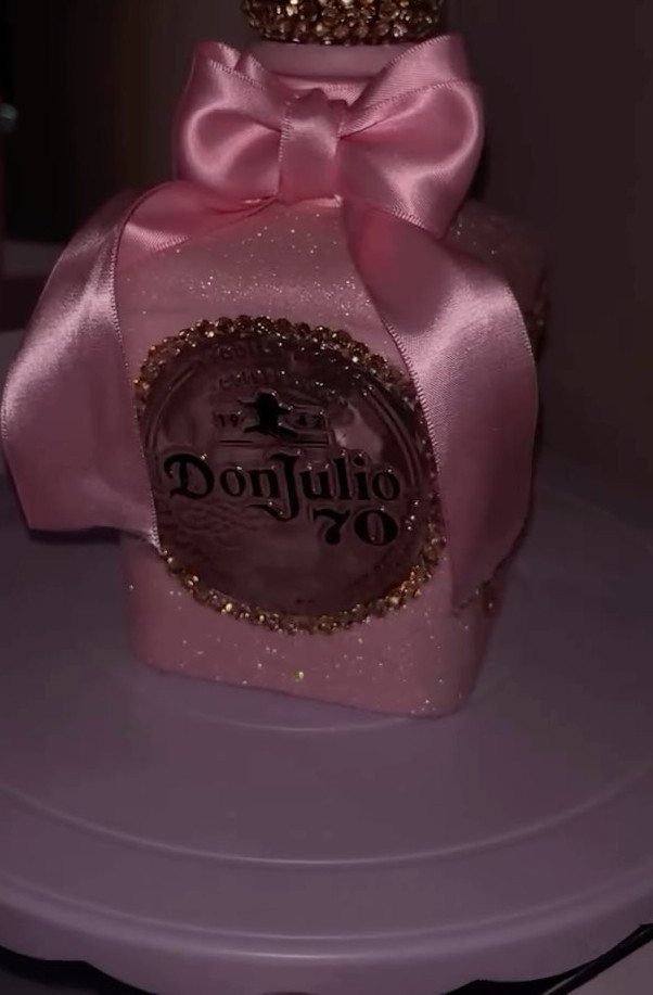 Pink glittery Don Julio tequila bottle with a large pink satin bow.