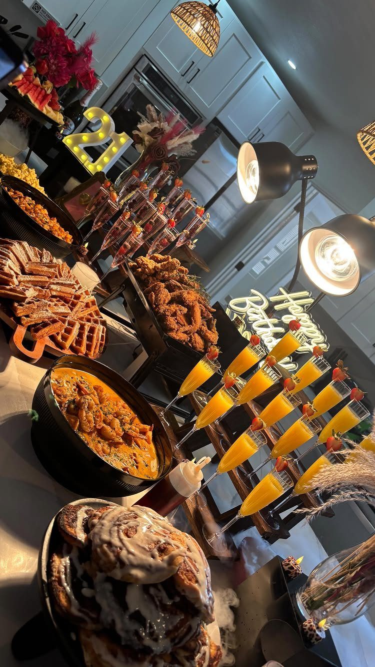Brunch spread with mimosas, cinnamon rolls, and a glowing 21 birthday sign.