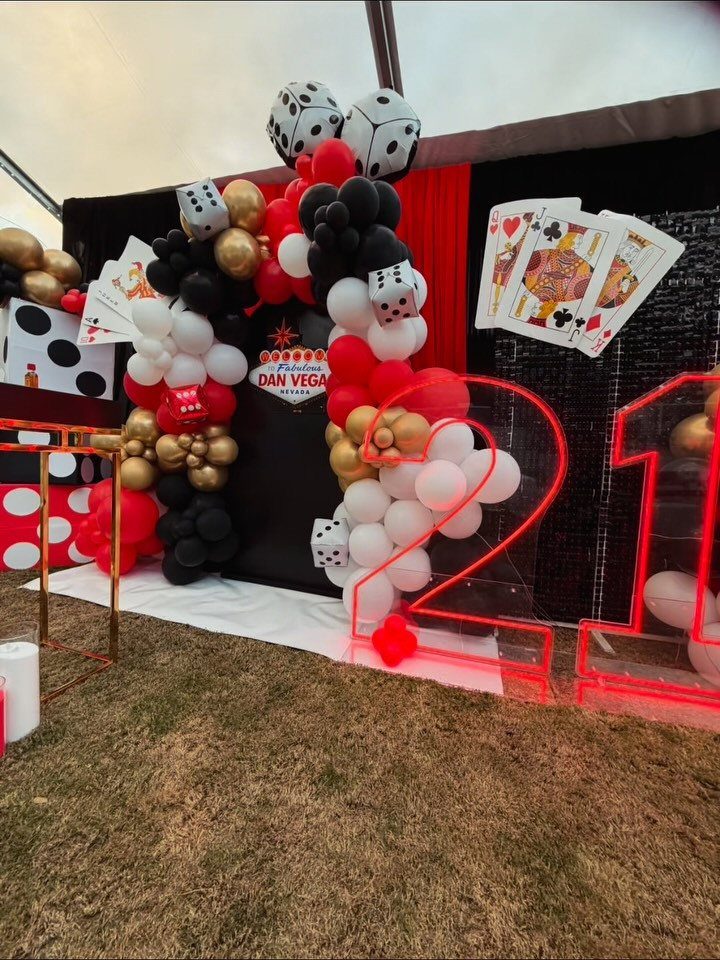 Casino themed 21st birthday decorations with red and black balloons and neon numbers.