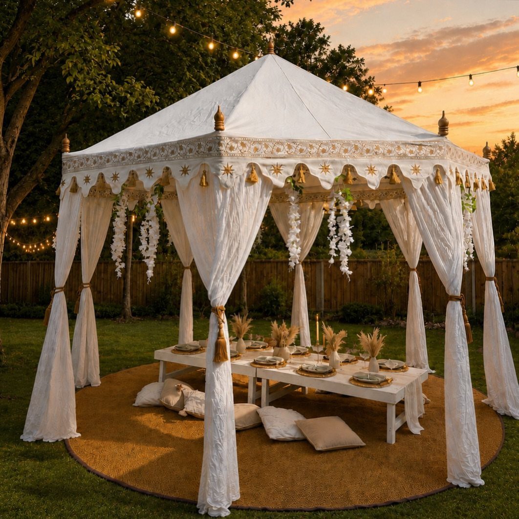 Ornate white canopy tent with a low dining table set on a lawn