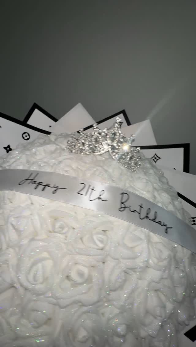 White rose bouquet with a silver tiara and Happy 21th Birthday ribbon.