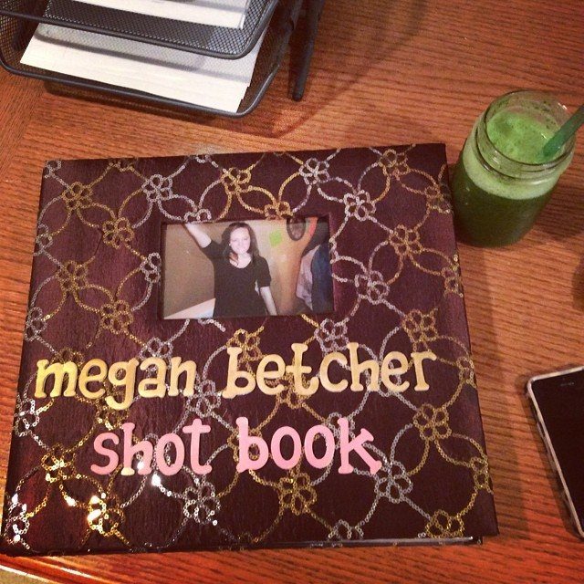 Handmade shot book with purple glitter cover and gold floral patterns on wooden table