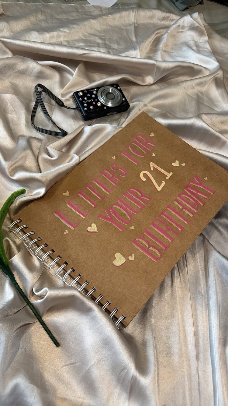 Brown spiral notebook for 21st birthday letters on champagne satin with a camera