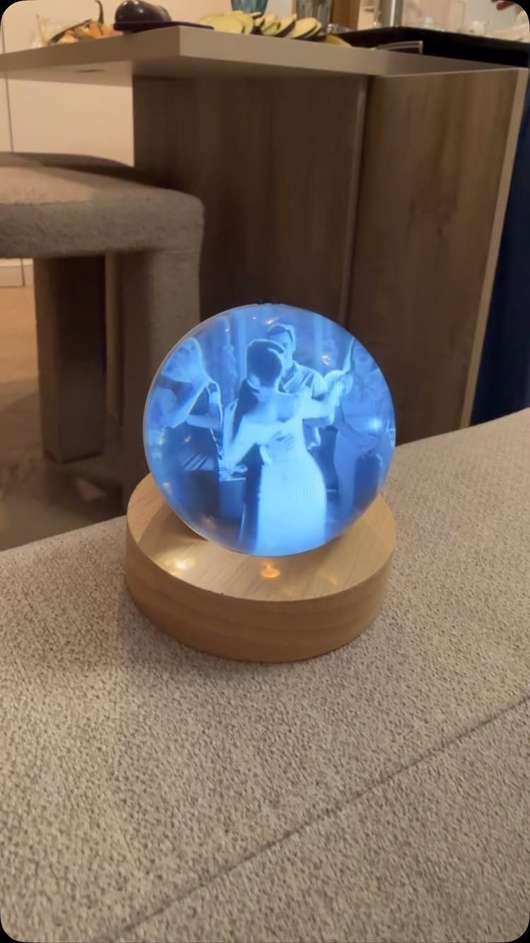 Glowing blue 3D memory crystal with etched couple on a wooden base