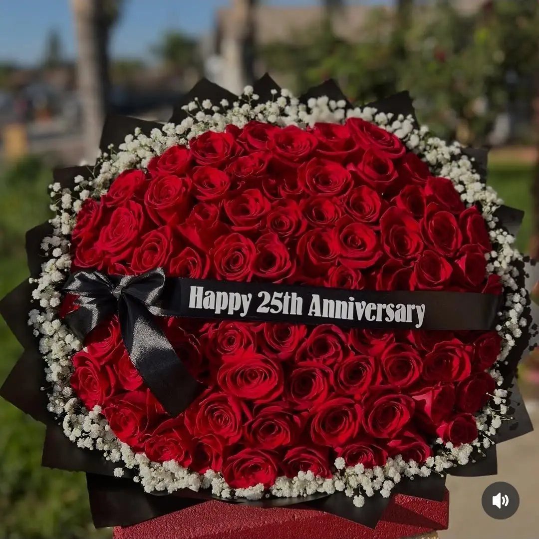 Red rose bouquet with baby's breath and a Happy 25th Anniversary ribbon.