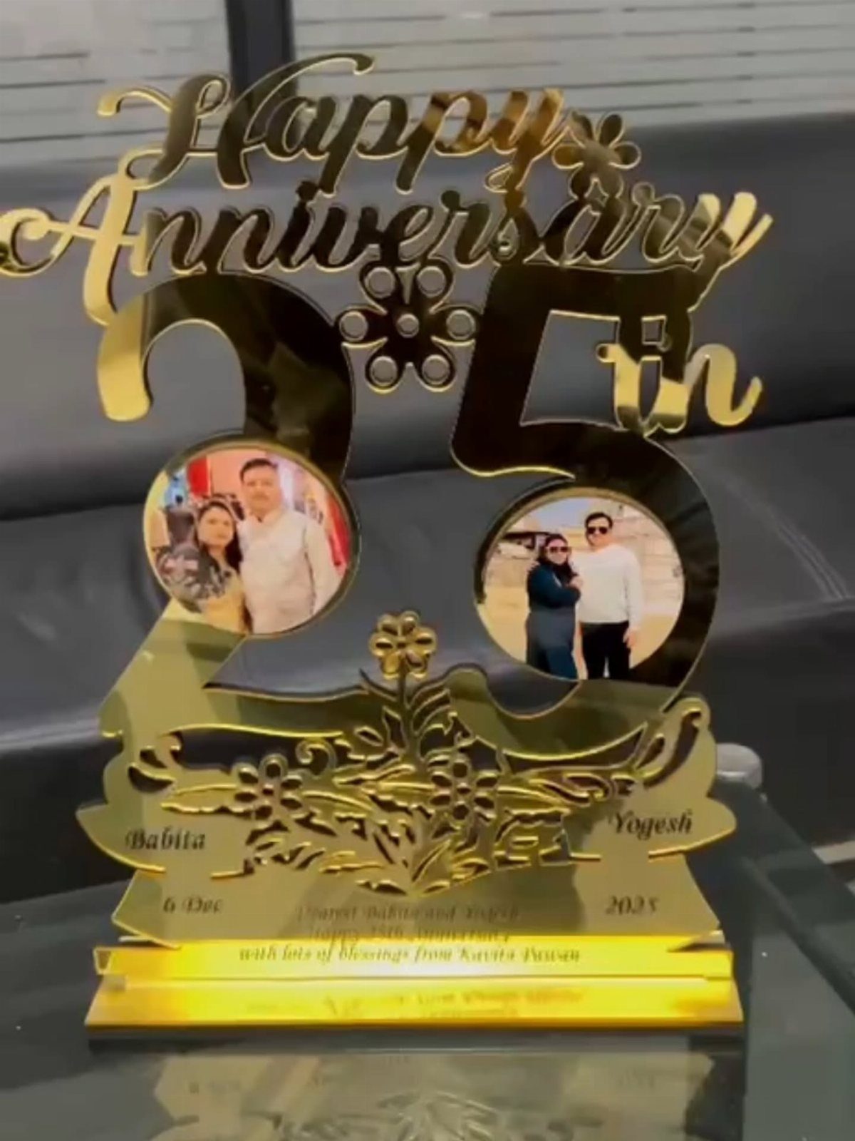 Gold metallic 25th anniversary trophy with two circular photos of a couple.