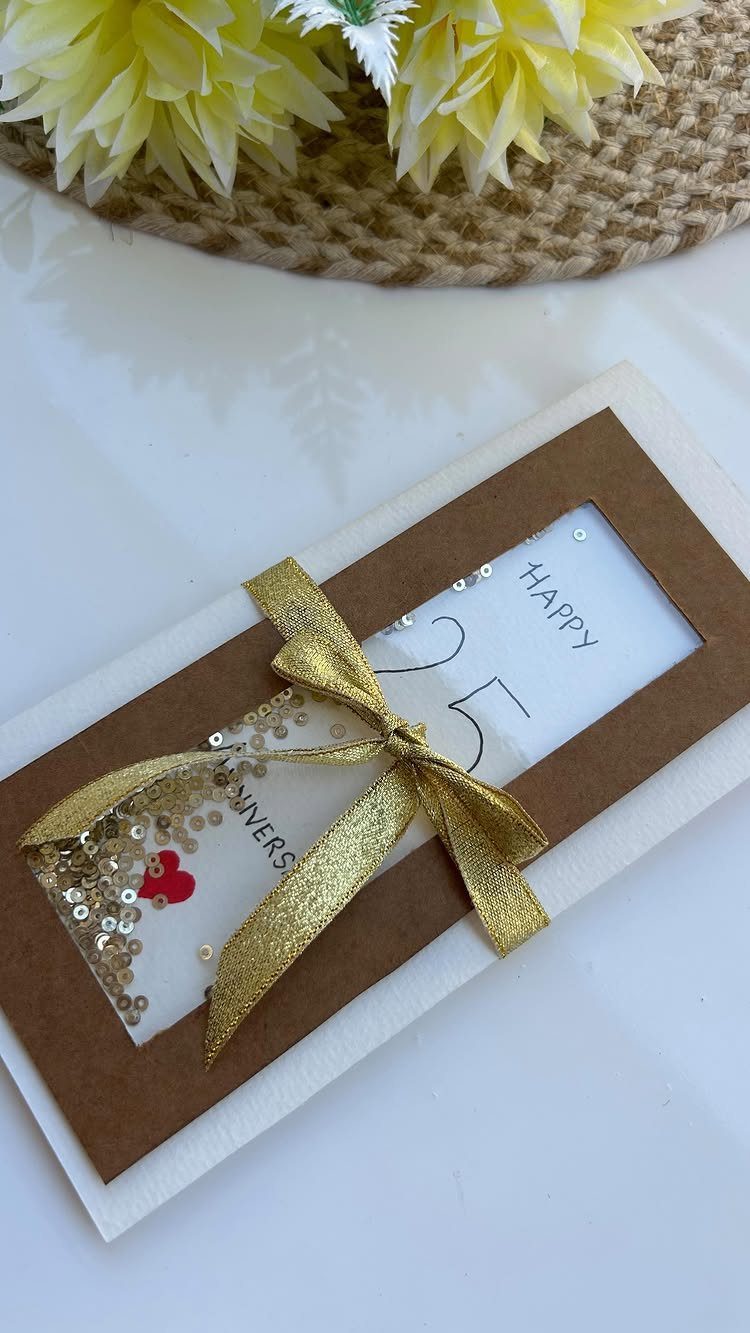 Handmade 25th anniversary card with gold ribbon, sequins, and handwritten celebratory text.