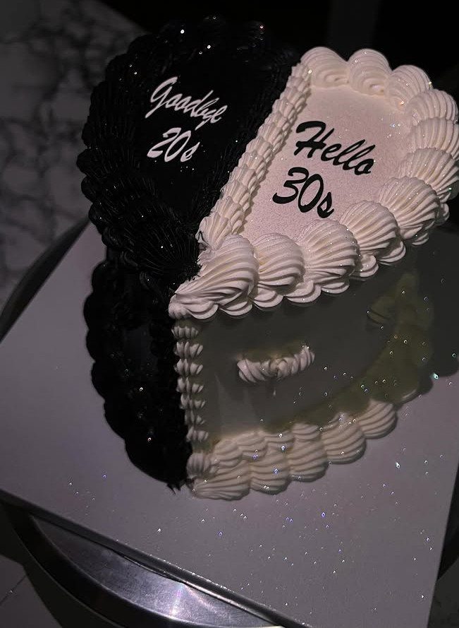 Heart-shaped cake split black and white with Goodbye 20s and Hello 30s text.