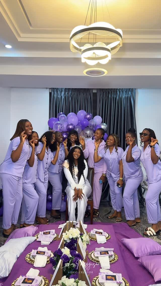 Women in purple pajamas celebrating around a woman in white with purple decorations.
