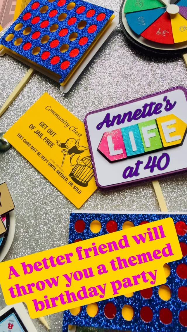 Game pieces and cards for a 40th birthday party on silver glitter background
