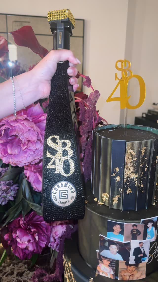 Black glittery tequila bottle and matching black cake with gold 40th birthday decorations