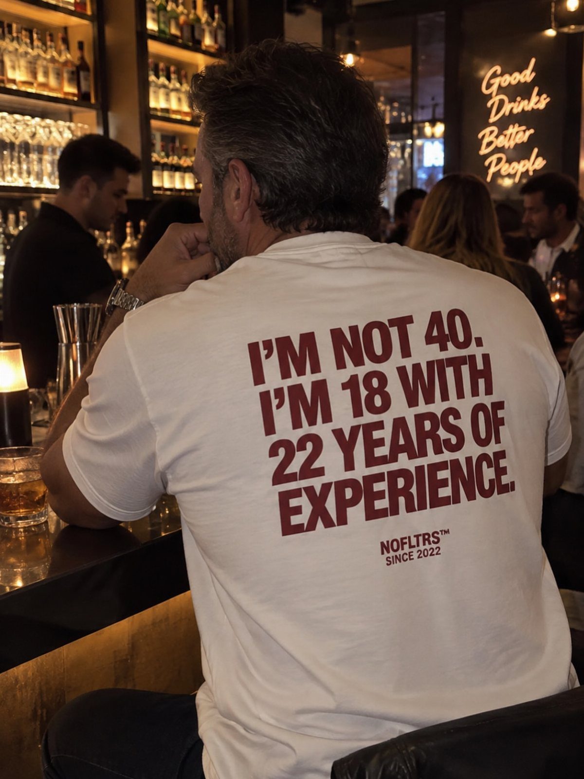 Man wearing a white t-shirt with a funny 40th birthday quote at a bar