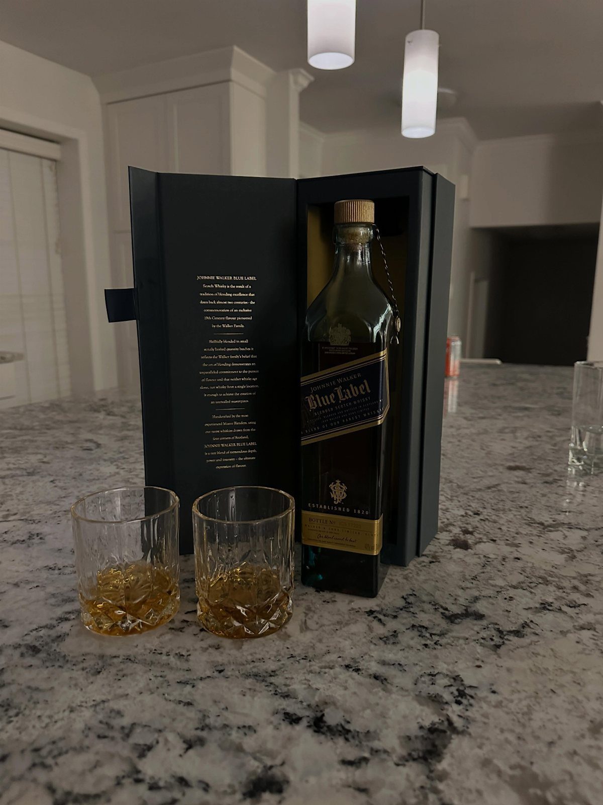 Johnnie Walker Blue Label whiskey bottle in box with two glasses of whiskey