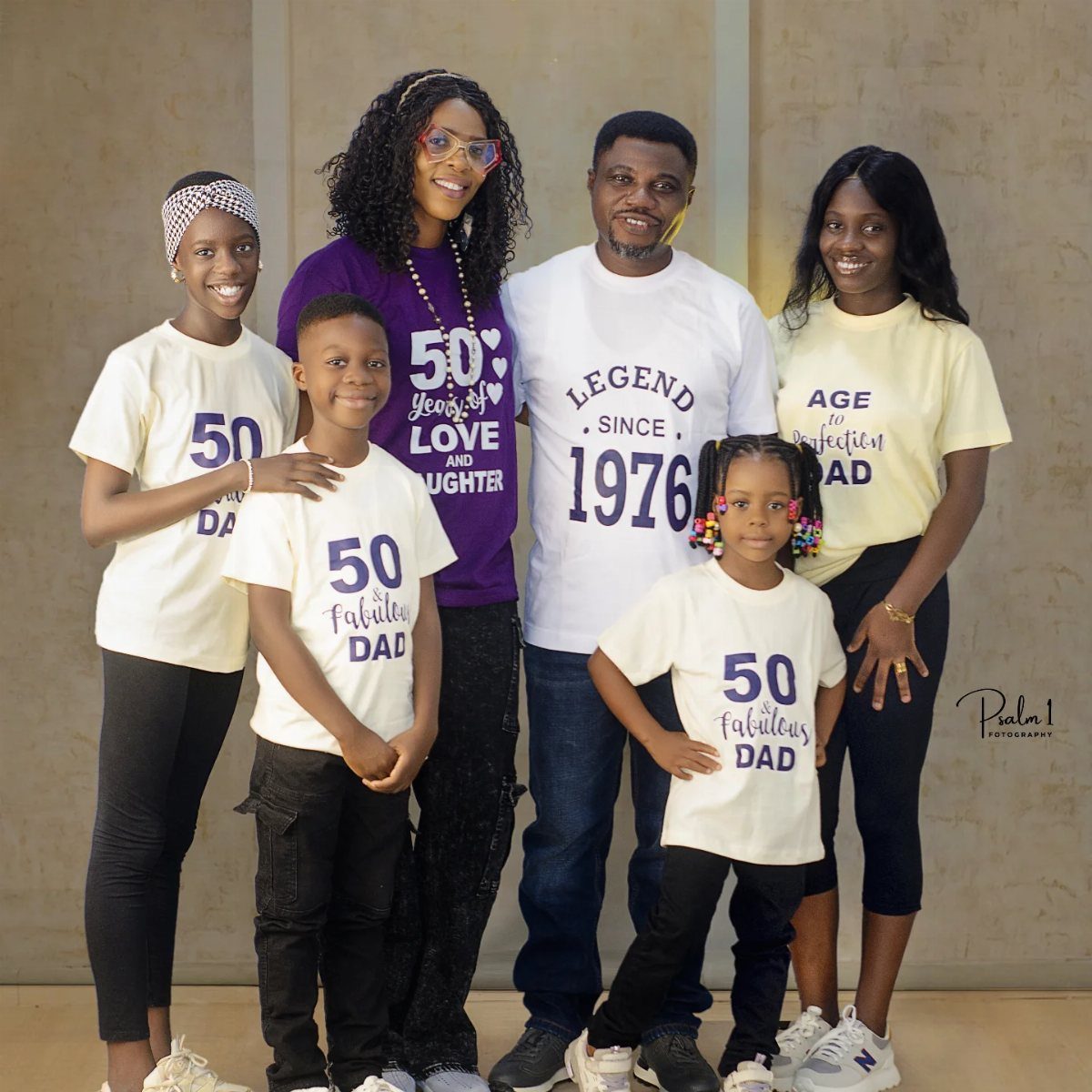 Family posing for a professional portrait wearing matching 50th birthday celebration t-shirts.