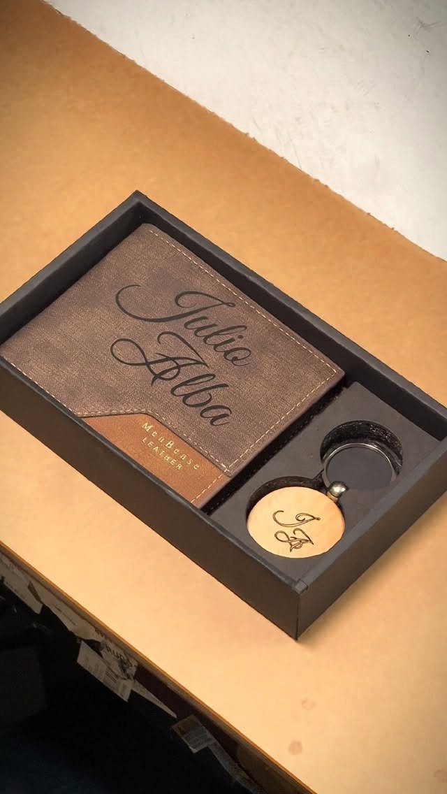 Personalized brown leather passport holder and keychain set in a black gift box.