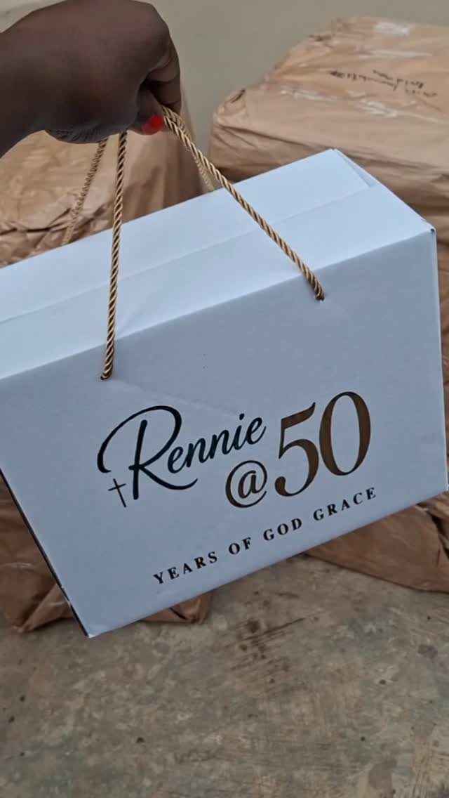 White gift box with gold handles and Rennie @ 50 text for birthday.