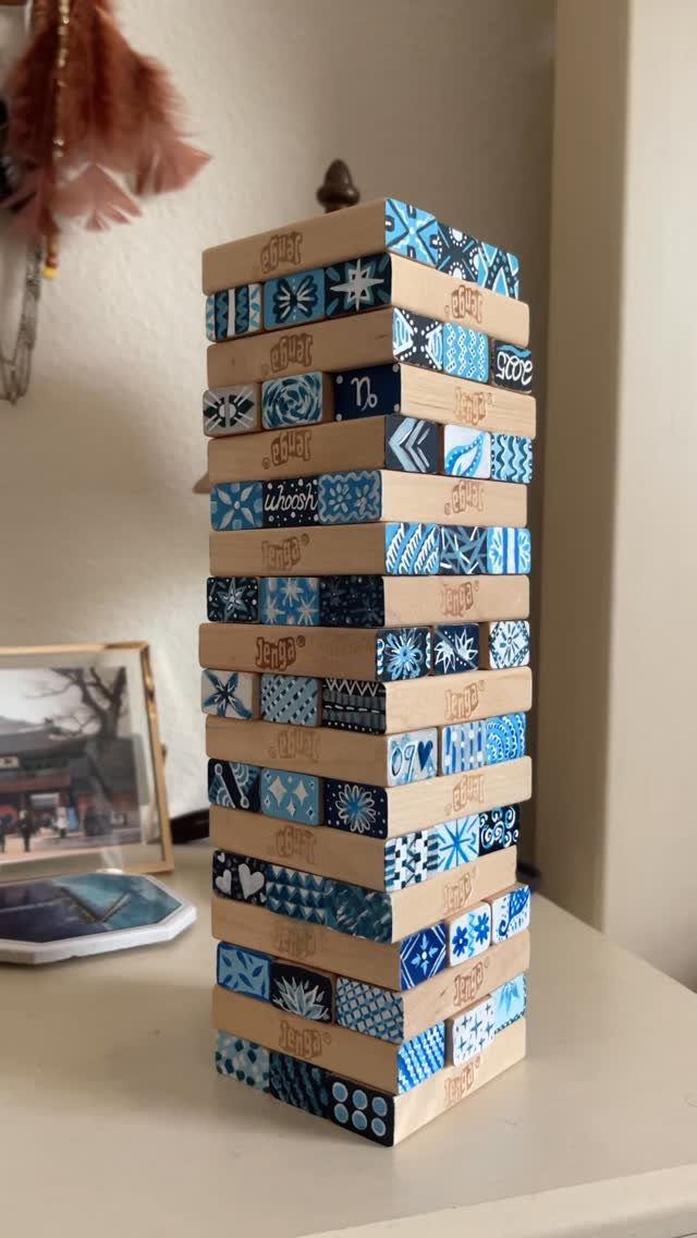 Wooden block tower game with blue decorative patterns on a white table