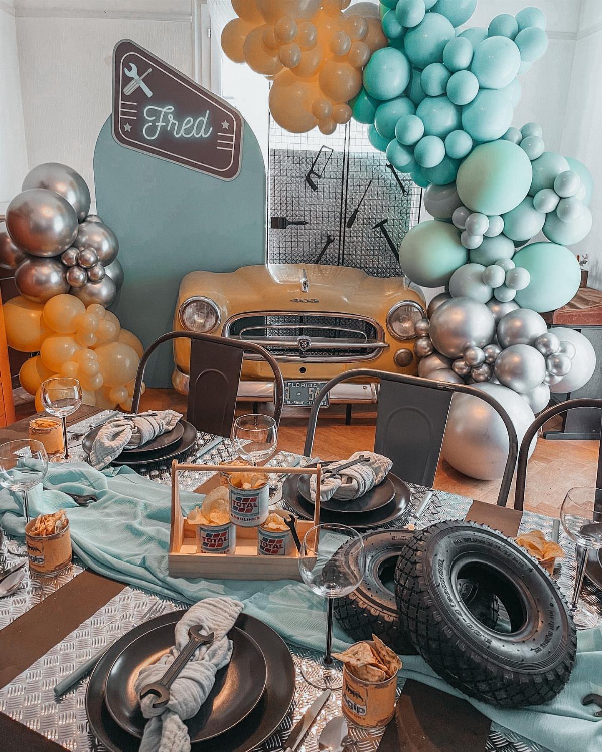 Vintage car themed party table with balloon arches and automotive decor for Fred.
