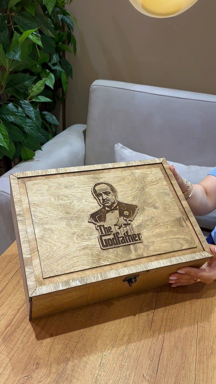 Wooden gift box with The Godfather carving held over a wooden table