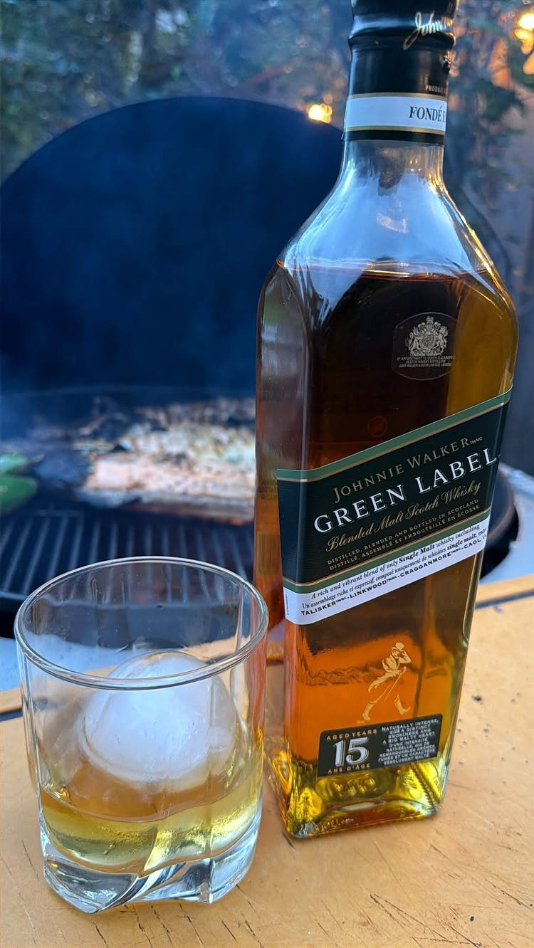 Johnnie Walker Green Label whisky bottle and a glass with a large ice sphere.