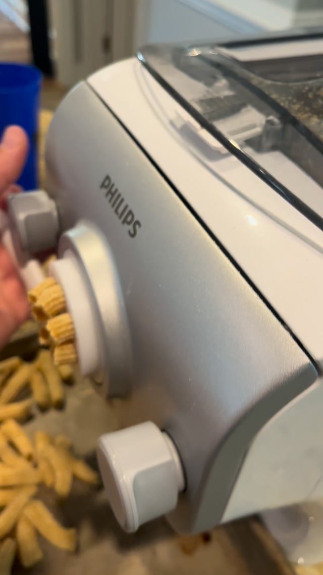 Philips automatic pasta maker extruding fresh yellow pasta into a metal tray