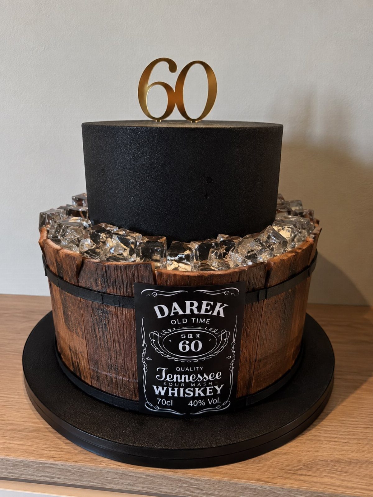 Two-tier birthday cake designed as a whiskey barrel with a gold 60 topper.