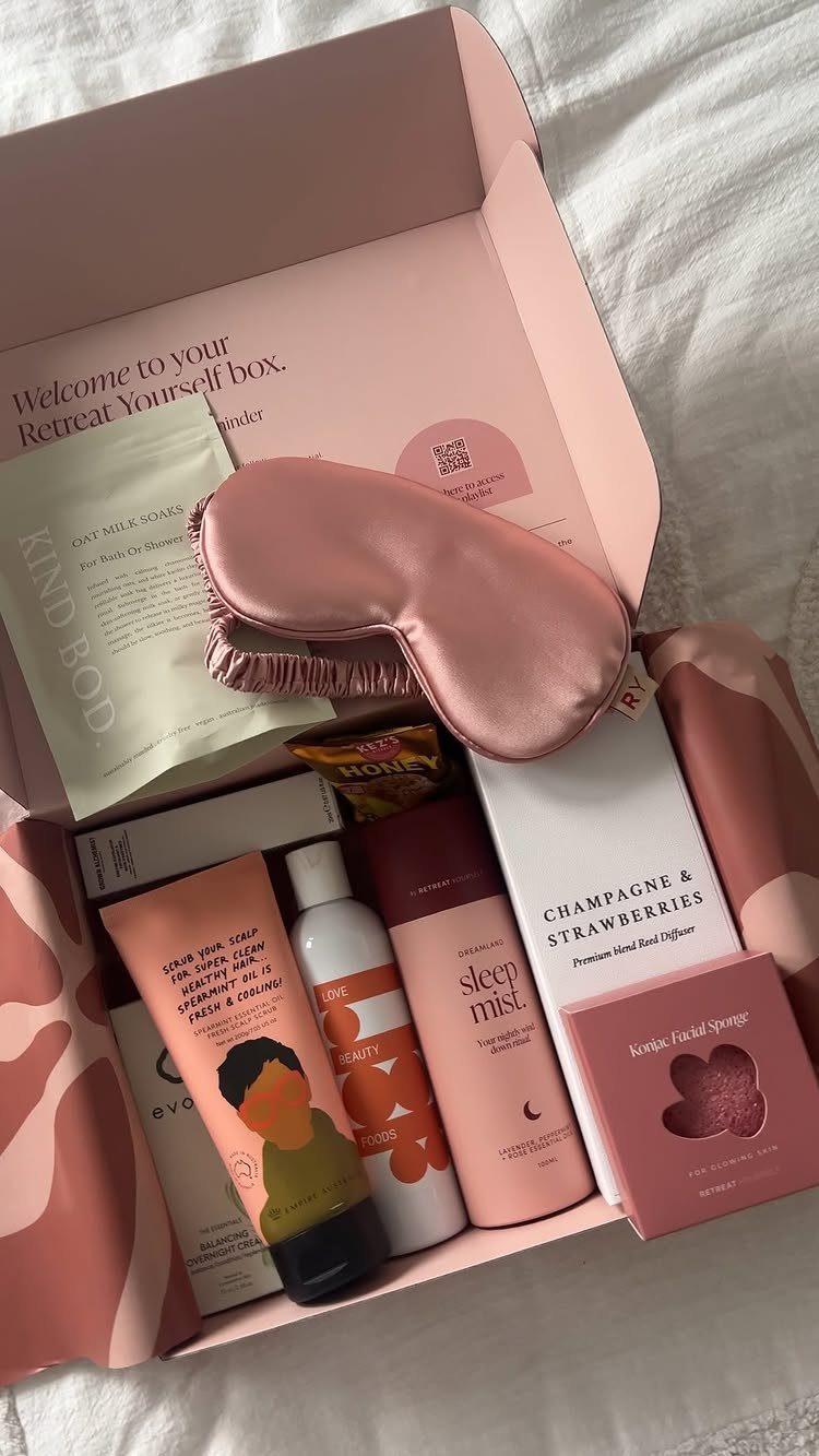 Pink self-care subscription box containing a sleep mask, lotions, and bath products.