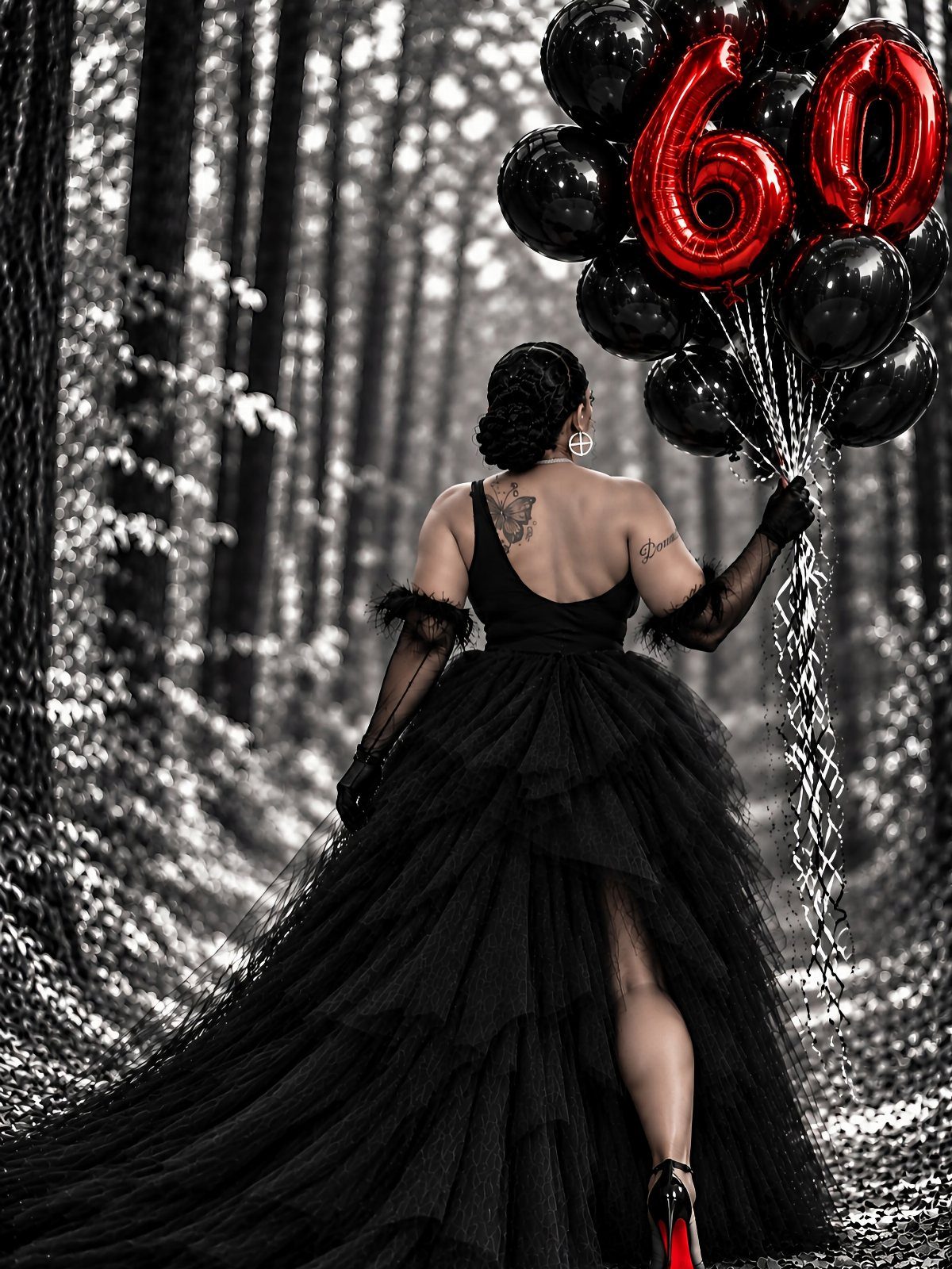 Woman in black gown holding red 60 balloons in a monochrome forest