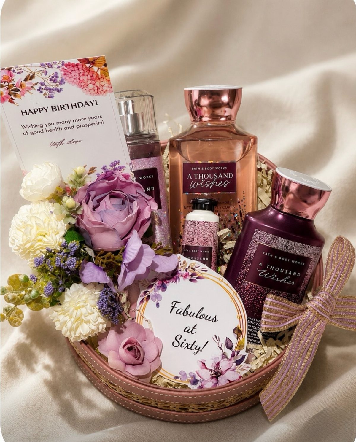 Birthday gift basket with purple flowers, fragrances, and a Fabulous at Sixty card.