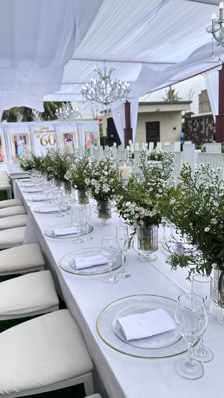 Elegant white dinner table setting with flowers and a 60th birthday sign
