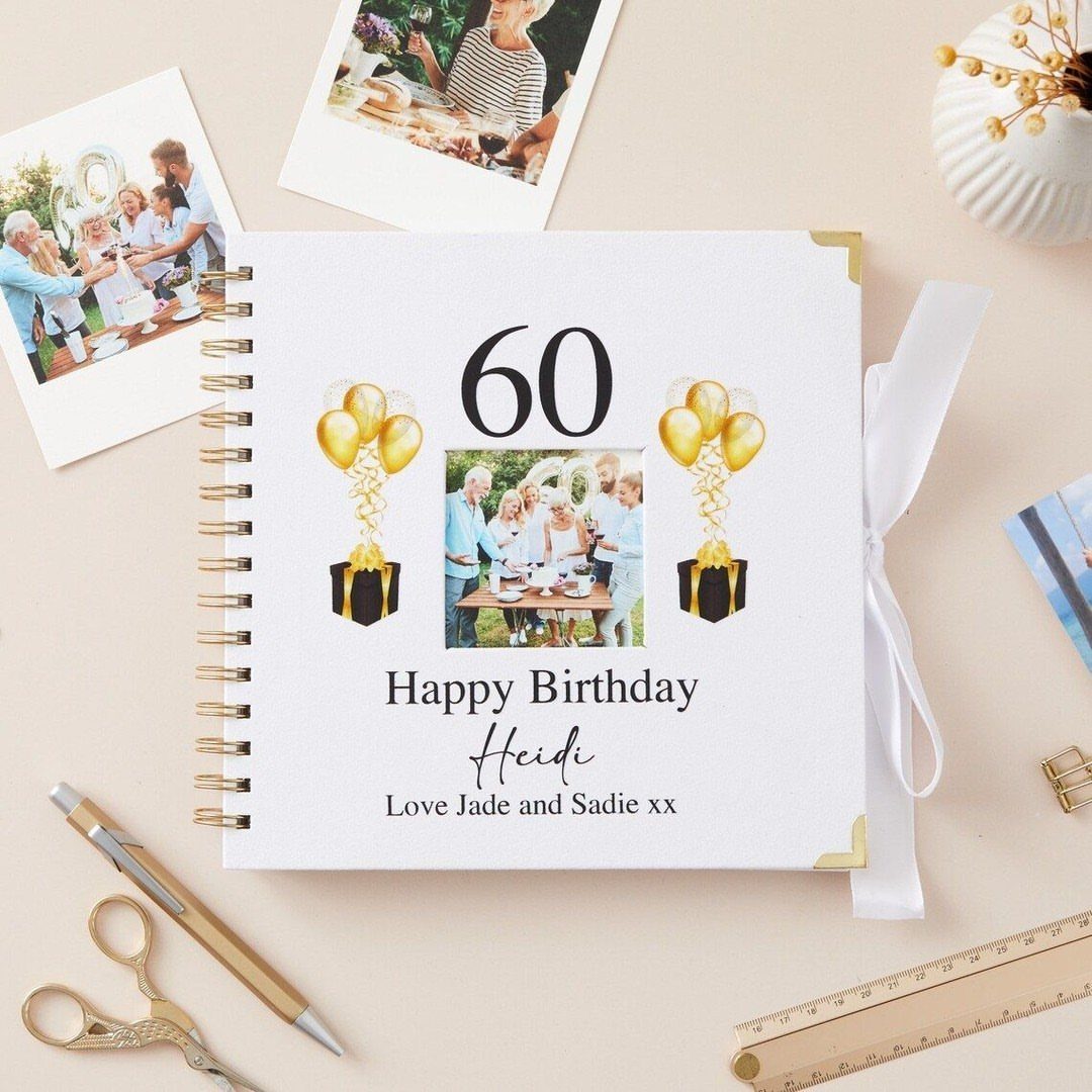 Personalized 60th birthday memory book with family photos and gold balloon decorations.