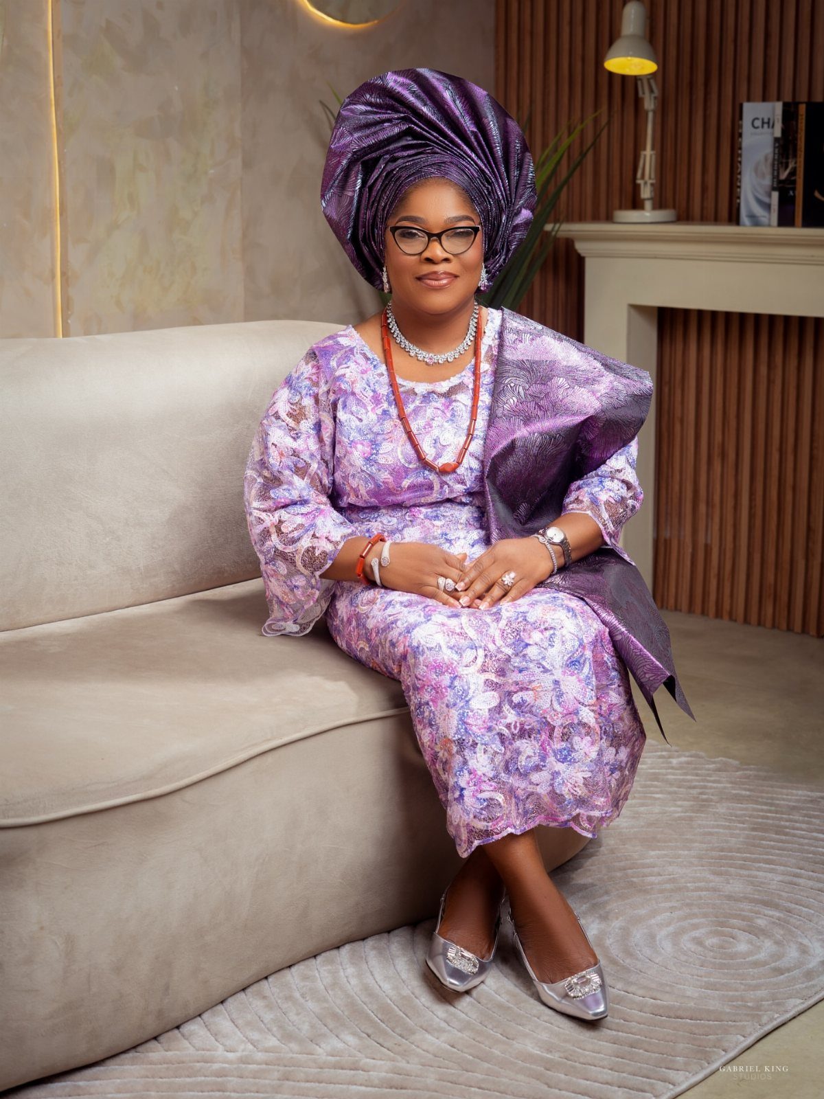 Woman in purple traditional Nigerian attire posing for a professional studio portrait.
