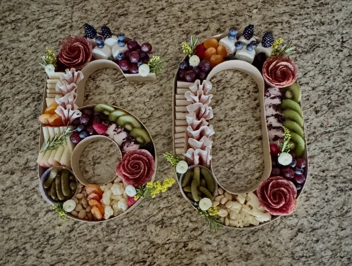 Charcuterie board shaped like the number 60 filled with meats, cheeses, and fruits.