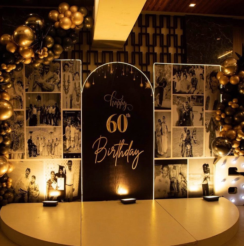 60th birthday party backdrop with gold balloons and a wall of family photos