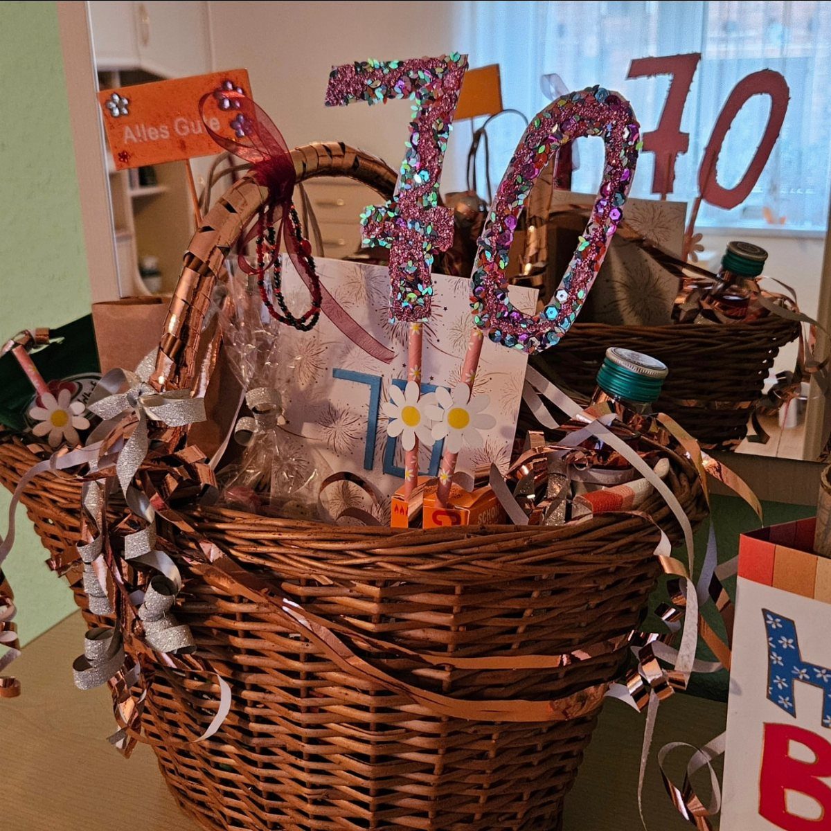 Wicker gift basket decorated with ribbons and a glittery purple number 70.