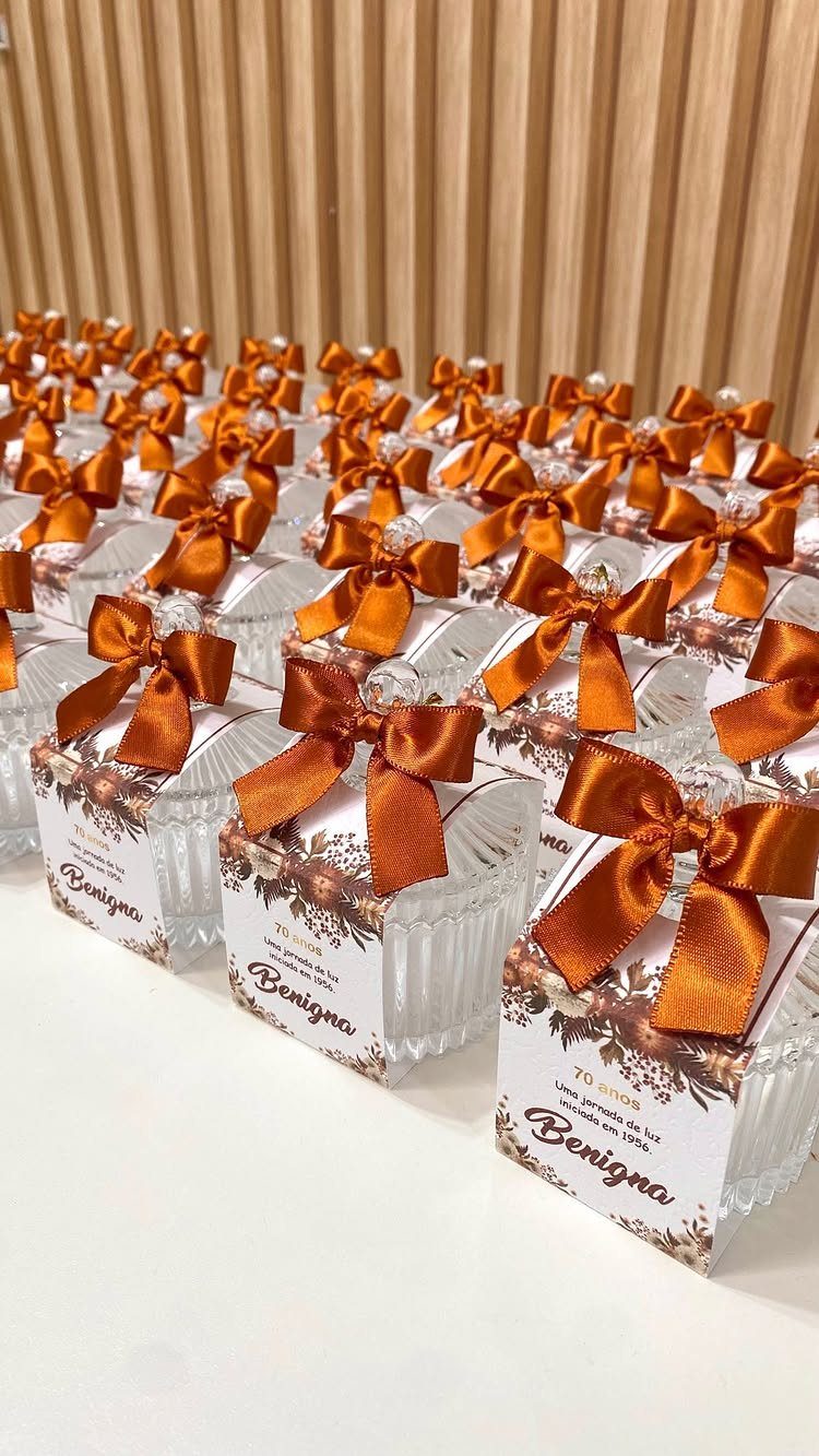 Small glass gift jars with copper bows and 70th birthday labels for Benigna.